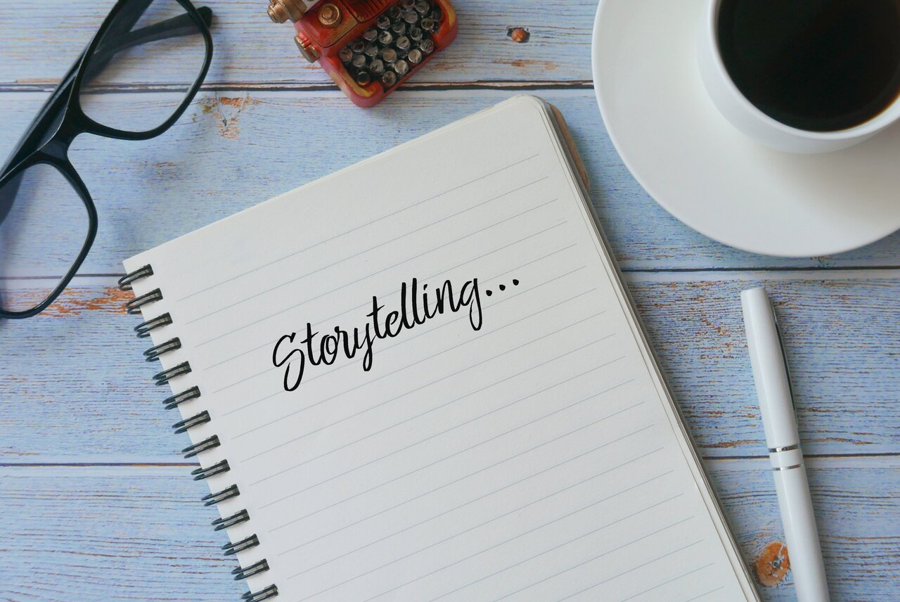 A notebook with the word storytelling on it next to a cup of coffee.