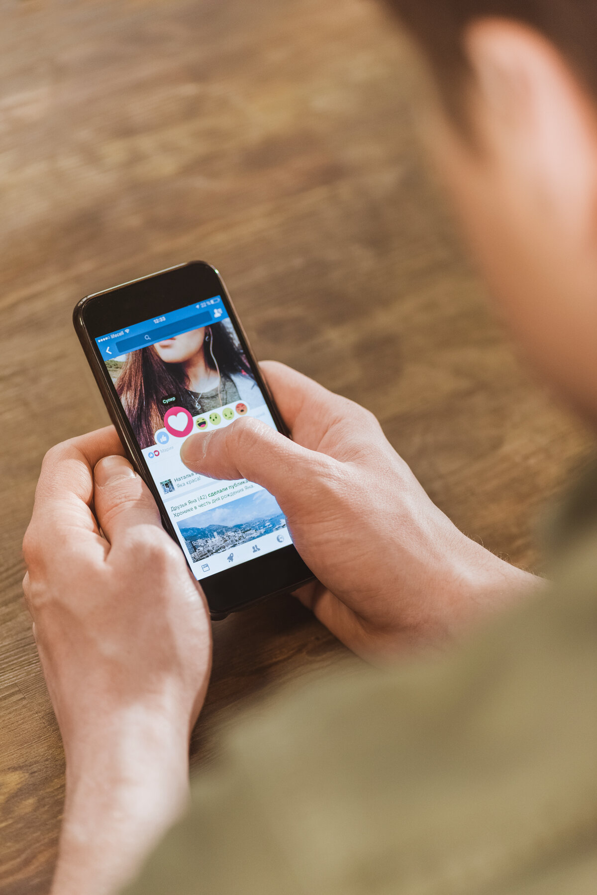 man using Facebook on smartphone