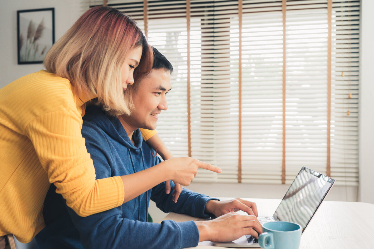 Young asian couple managing finances, reviewing their bank accou